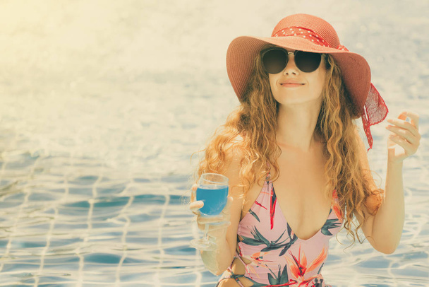 Happy young woman wearing swimsuit having good time at swimming pool in luxury resort. Summer travel holiday concept. - Φωτογραφία, εικόνα