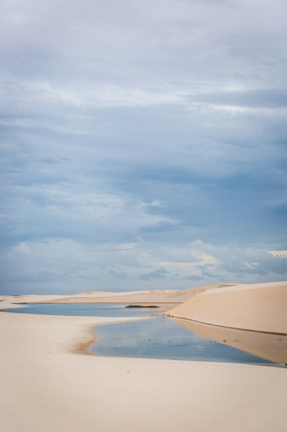 Amazing white sand dunes with natural pool lagoons in the middle of it, cloudy day. Reflection in the water. - Foto, Bild