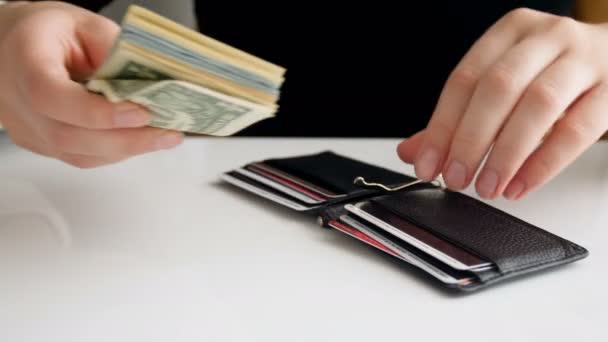 Nahaufnahme 4k Filmmaterial von Geschäftsfrau, die einen Stapel Dollars steckt und versucht, die Brieftasche zu schließen - Filmmaterial, Video