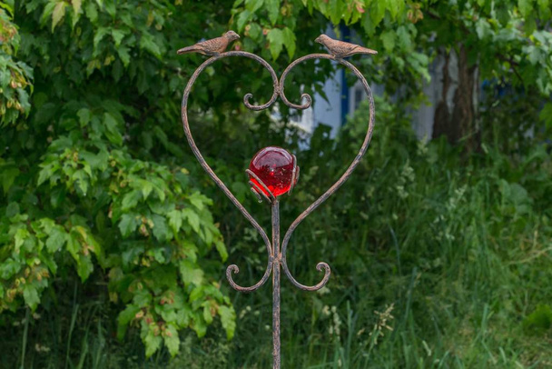 Bouchon de jardin en forme de coeur décoré d'une boule de verre rouge
 - Photo, image