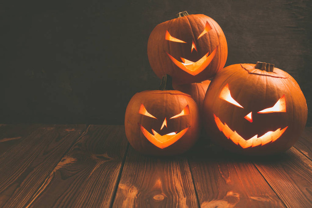 Spooky carving halloween pumpkins on wooden plank. Halloween background. - Фото, изображение