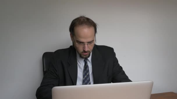 Middellange frontale schot van Office jonge zakenman bezorgd werken met laptop - Video