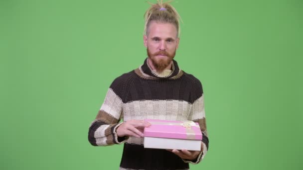 Handsome bearded man smiling while opening gift box - Filmagem, Vídeo