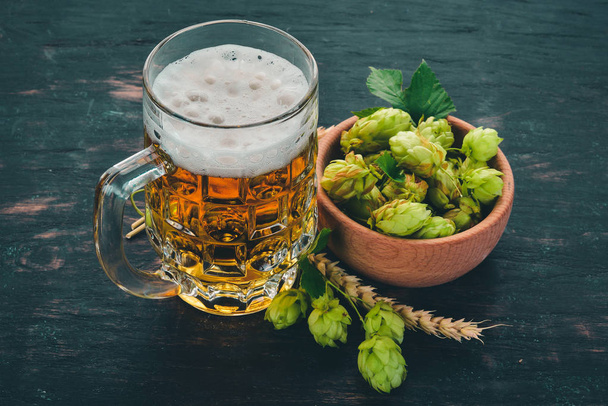 Beer in a glass mug. On a black wooden table. Free space for text. Top view. - Fotografie, Obrázek