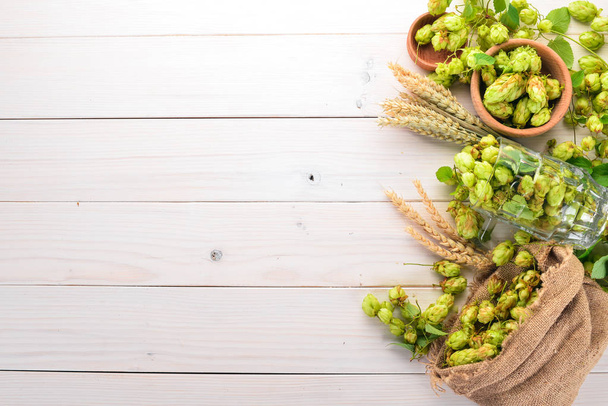 Hops and wheat. On a white wooden table. Free space for text. Top view. - Fotoğraf, Görsel