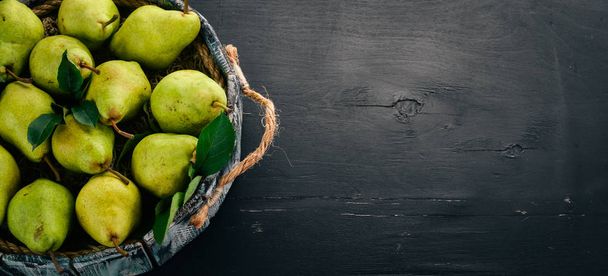 Fresh green pear. Assortment of pears in a wooden box. On the black table. Free space for text. Top view. - Foto, Imagem