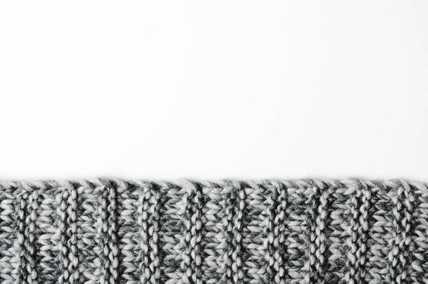 The edge of a gray knitted plaid on white background. Background, copy space. - Foto, Bild