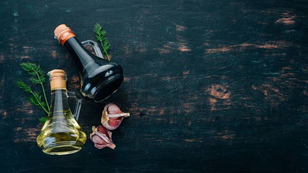 Olive oil and soy sauce in glass jars. Spices and Sauce. Top view. On a black wooden background. Free space for text. - Foto, imagen
