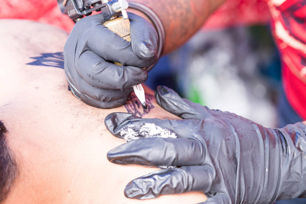 Closeup of tattoo grafting drawing onto body using tools and equipment - Photo, Image