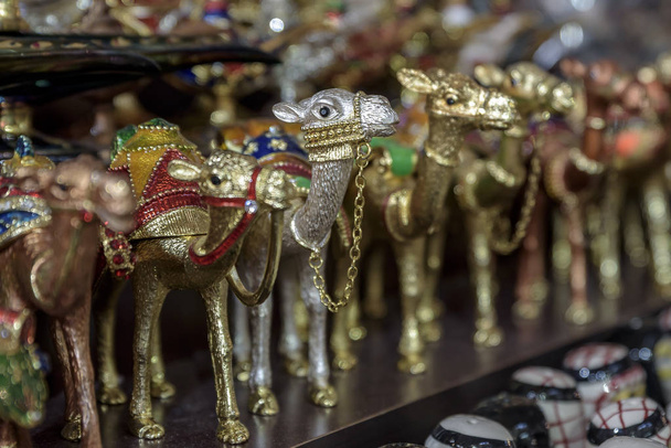 Värikäs, kamelin muotoinen helyjä, myytävänä souks Dubaissa, Arabiemiirikunnissa
 - Valokuva, kuva