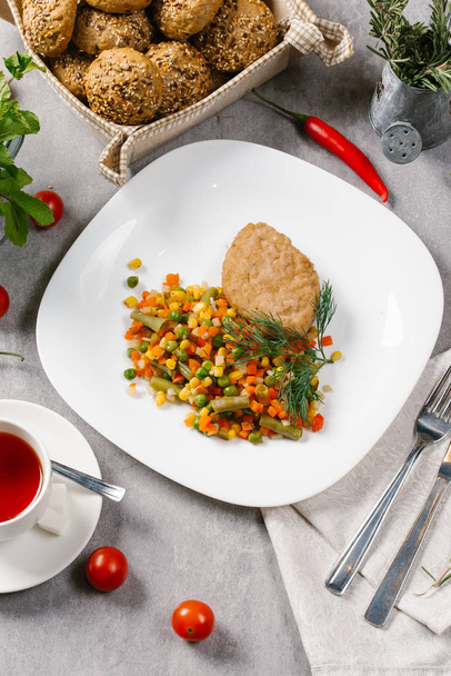 Viande rôtie servie avec des légumes cuits dans une assiette blanche
 - Photo, image