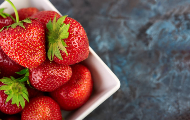 Fresh red strawberry on a dark abstract background. Summer berries. The concept of healthy eating. - Photo, Image