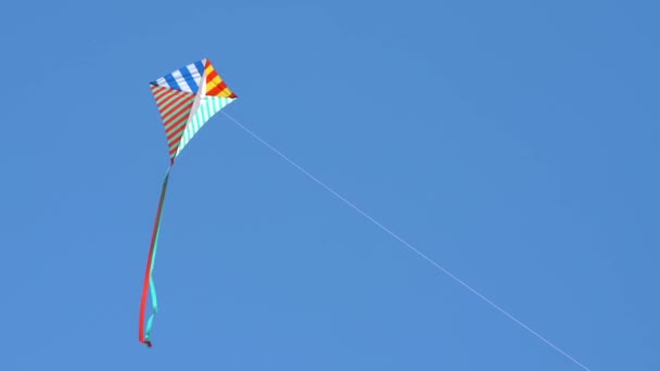 Bunte Drachen fliegen gegen blauen Himmel und Sonne - Filmmaterial, Video