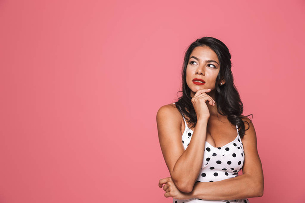 Image of thinking woman in swimwear posing isolated over pink wall background looking aside. - Фото, зображення