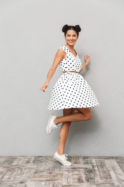 Full length portrait of a happy young woman in summer dress isolated, posing while standing - Photo, Image