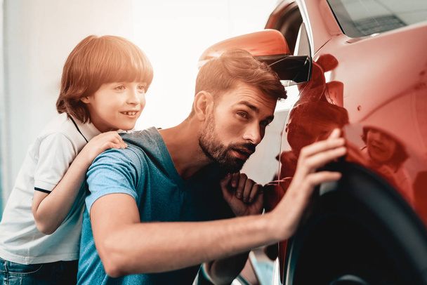 Young Family Are Choosing A New Car In Showroom. Automobile Salon. Father And Son. Good Mood. Make A Desicion. Auto Rewiew. Quality Control. Reliability Mark. - Fotografie, Obrázek