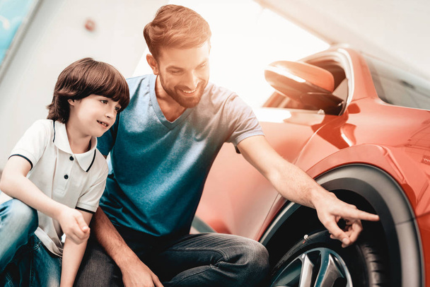 Young Family Are Choosing A New Car In Showroom. Automobile Salon. Father And Son. Good Mood. Make A Desicion. Auto Rewiew. Quality Control. Reliability Mark. - Fotografie, Obrázek
