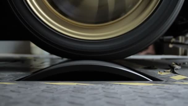 Závodní auto auto kolo spinning na dyno zkušebních zařízení - Záběry, video
