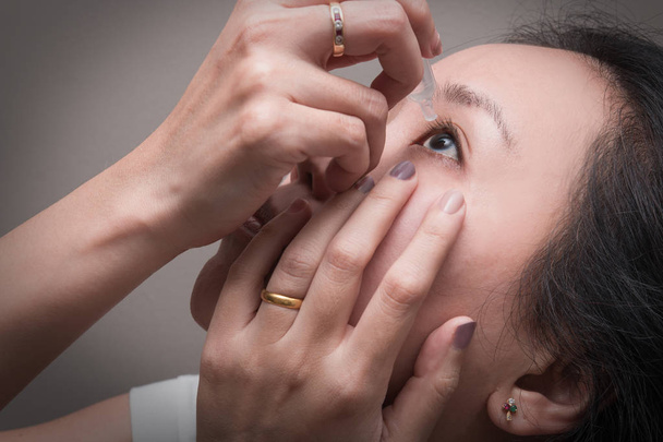 Asyalı Genç kadın göz damlası göz tedavisi için kullanır. Kızarıklık, Kuru göz, alerji ve göz kaşıntı - Fotoğraf, Görsel
