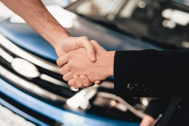 Customer And Buyer Are Shaking Each Other Hands. Automobile Salon. Make A Decision. End Of A Deal. Good Offer. New Buying. Business Trade. Professional Sale. Car Showroom. Dialogue With Dealer. - 写真・画像