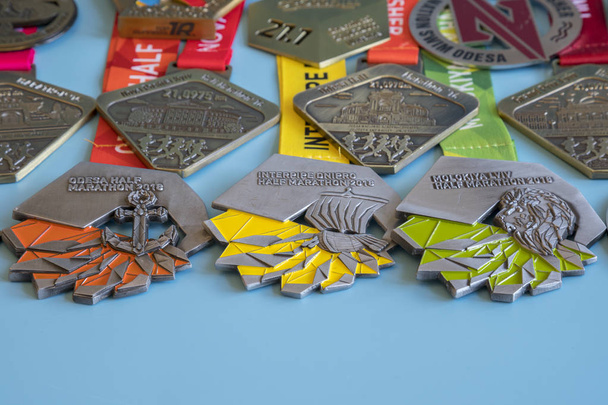 Kiev, Ukraine. September 2 2018 Many different sports medals on a blue background. Medals for a half marathon on a blue background. - Photo, Image