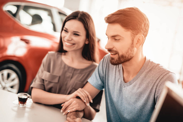 Happy Young Family Are Choosing A New Car In Showroom. Dialogue With Dealer. Automobile Salon. Make A Decision. Cup Of Coffee. End Of A Deal. Good Offer. New Buying. Business Trade. - Valokuva, kuva