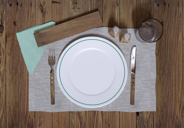 3D realistic render of empty plate on wooden table. Salt, pepper, serviette, glass of water and wooden cutlery. Isolated on white background. - Zdjęcie, obraz