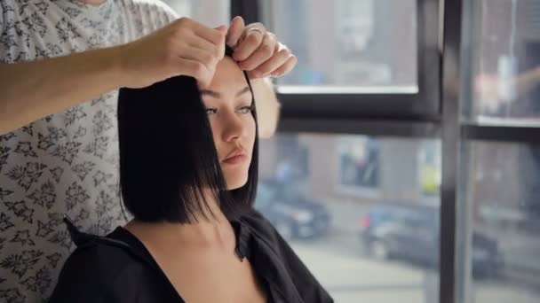 Mujer joven mirando en el espejo después de corte de pelo
. - Imágenes, Vídeo