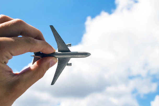 Toy airplane in hand on sky background - Photo, Image