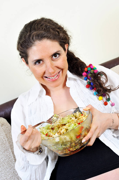 Високий кут зору щасливої вагітної жінки, що їсть салат
 - Фото, зображення