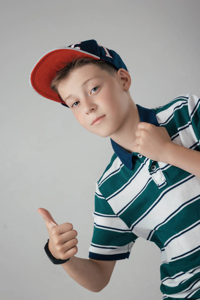 the boy is posing in a fashionable baseball cap in the studio - Photo, Image