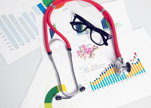 Stetoskop z sprawozdania finansowego, Okulary, leki - Zdjęcie, obraz