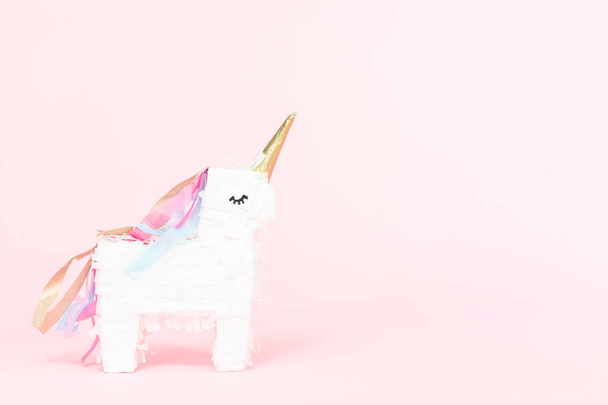 White unicorn pinata on a pink background. - 写真・画像