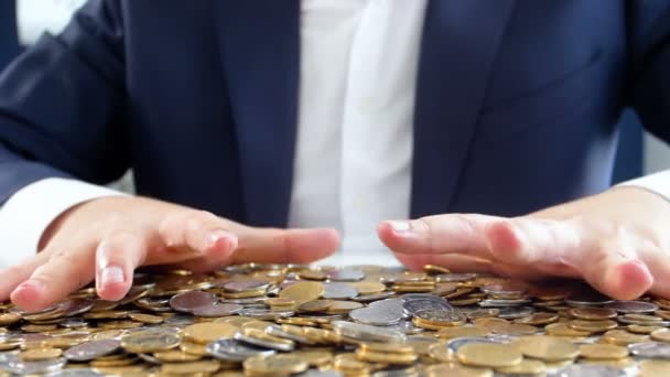Nahaufnahme Zeitlupenvideo gieriger Geschäftsmann, der Münzen ergreift, die auf dem Schreibtisch liegen - Filmmaterial, Video