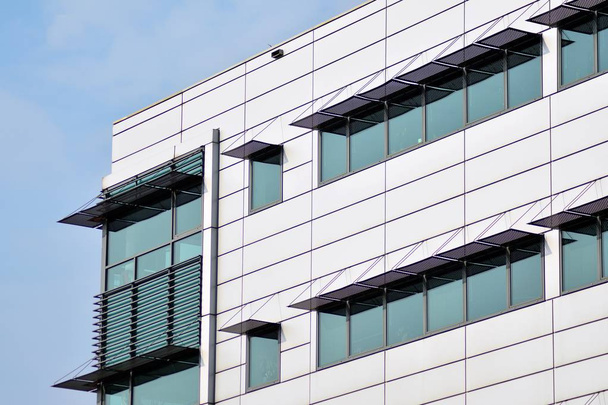 Streszczenie fragmentu współczesnej architektury, ściany wykonane ze szkła i betonu. Szklana ściana osłonowa z nowoczesny budynek biurowy - Zdjęcie, obraz