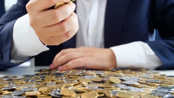 Zeitlupenaufnahmen gieriger Geschäftsleute, die einen großen Haufen Münzen in der Hand halten und auf den Tisch werfen - Filmmaterial, Video