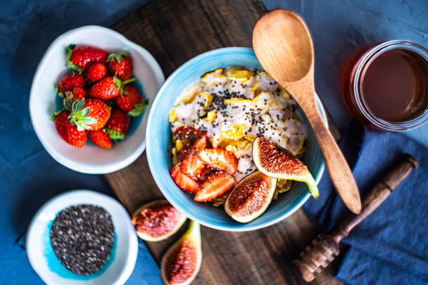 Traditional healthy breakfast with fresh organic strawberry and figs, chia seeds, yogurt and honey - Photo, Image