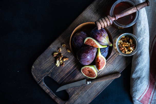 Herfst rijp fig vruchten in woode kom met honing en hutten als een seizoensgebonden voedsel concept - Foto, afbeelding
