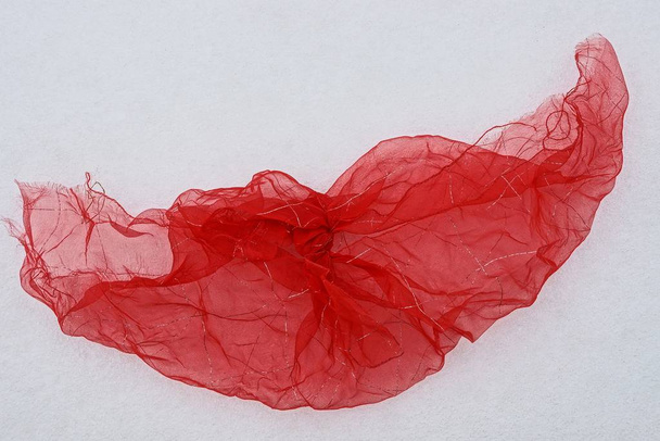 fragment de tissu lumineux froissé rouge sur neige blanche
 - Photo, image
