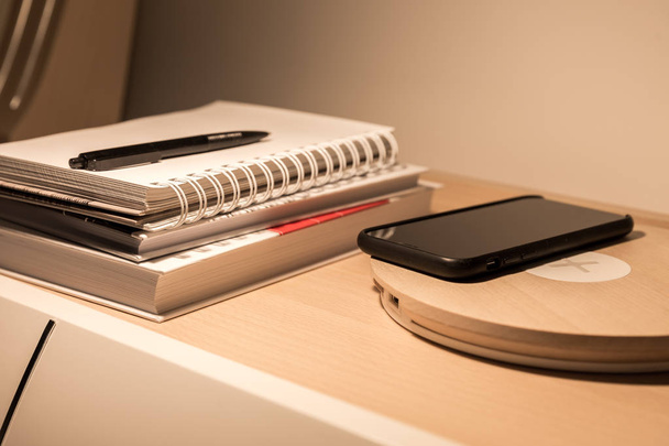 Smartphone-ban fekete esetben töltés vezeték nélküli ágy asztal - Fotó, kép