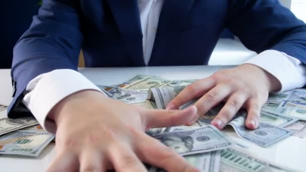 Αργή κίνηση βίντεο από άπληστους επιχειρηματίας grabing πολλά χρήματα ξαπλωμένος στο γραφείο - Πλάνα, βίντεο