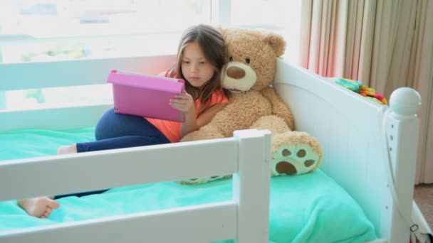 Tyttö käyttää digitaalinen tabletti sängyssä makuuhuoneessa kotona 4k
 - Materiaali, video
