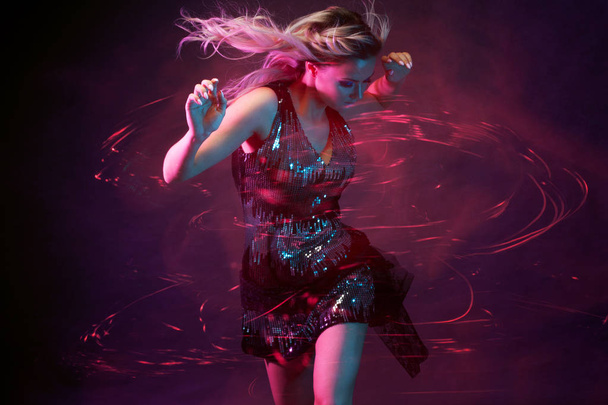 Attractive dancing blonde in the club, neon light, motion effects - Foto, afbeelding