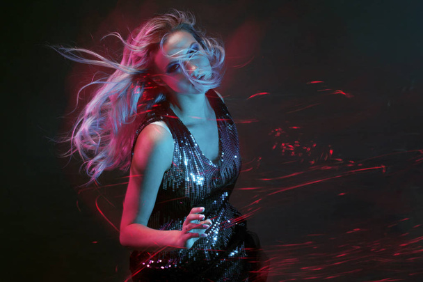 Jeune femme lumineuse et élégante dansant en club, lumière de couleur, effets de mouvement
 - Photo, image