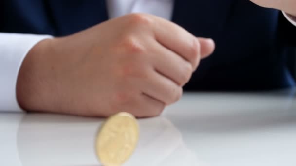 Nahaufnahme in Zeitlupe: junger Geschäftsmann dreht Münze auf Bürotisch - Filmmaterial, Video