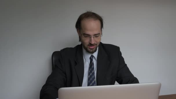 Medium frontal shot of Office young businessman relaxed working with laptop - Footage, Video