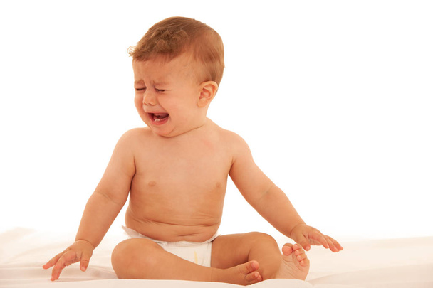Sad baby boy in crying on bed isolated over white - Foto, immagini
