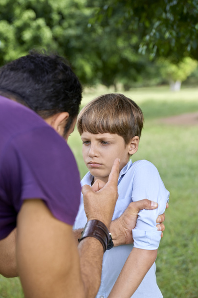 Parenthood and children education, angry man scolding boy in par - Photo, Image