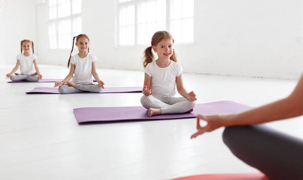 i bambini che praticano sono impegnati in ginnastica e yoga con teache
 - Foto, immagini