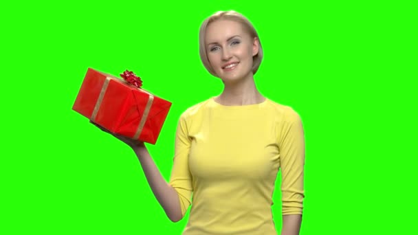 Mooie rijpe vrouw in gele trui holding rode geschenkdoos. - Video